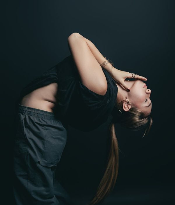 Woman in a calm yoga pose in a dimly lit room, suggesting relaxation and sleep.